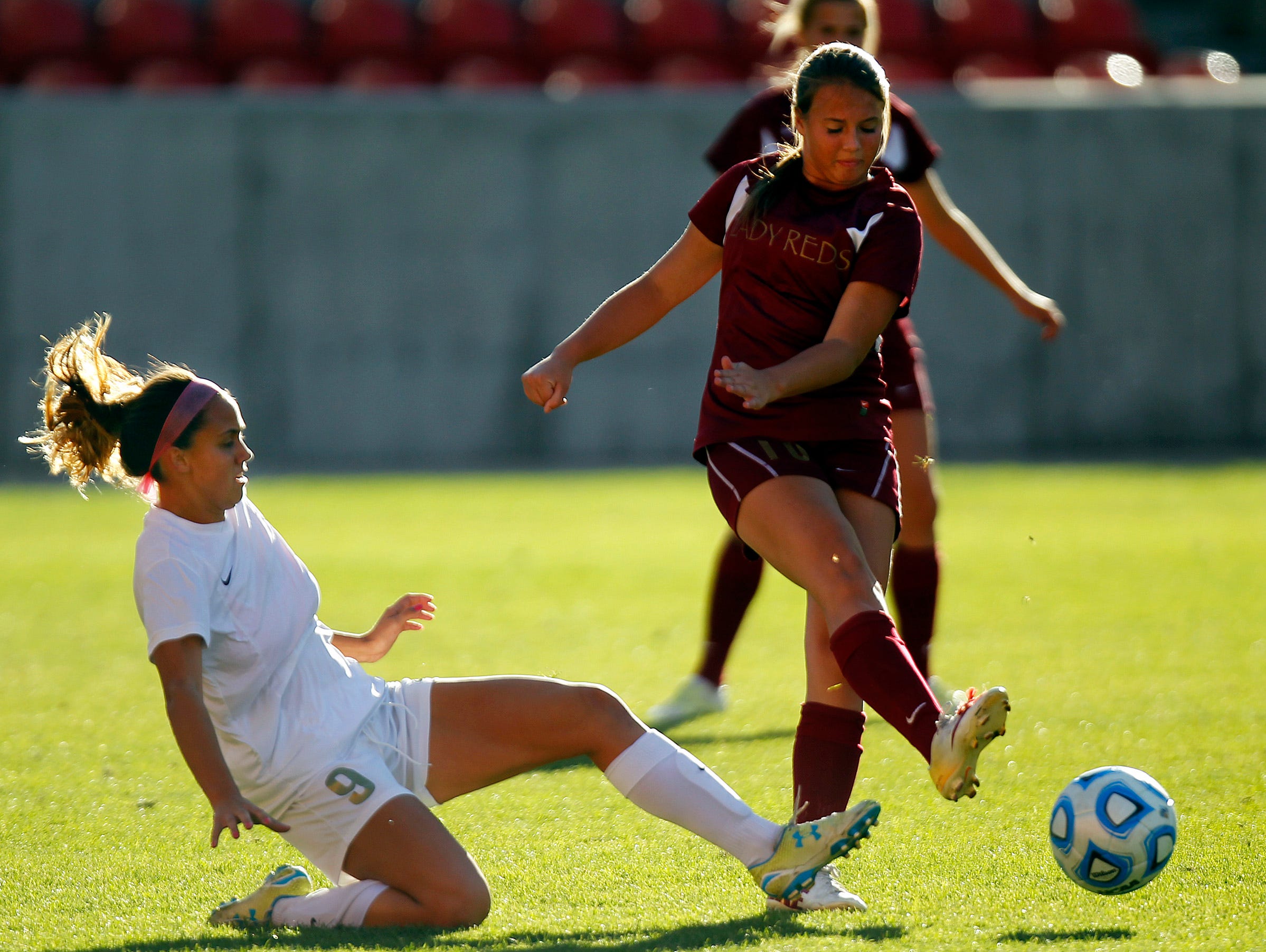 Cedar's Bailey Robinson kicks the ball away from Logan's Demi Lopez in the Girls 3A State Soccer Championship at Rio Tinto Stadium in Sandy on Saturday.