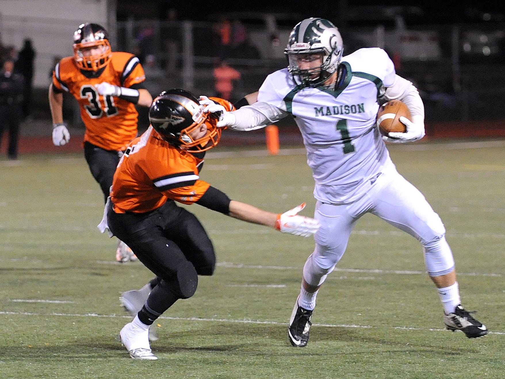 Madison's Billy Buckley stiff arms an Ashland player during their game Friday night.