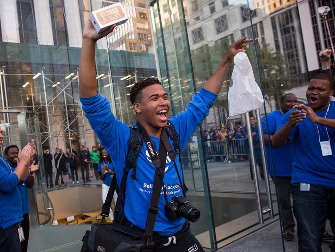 Brian Ceballo, who waited outside the Fifth Avenue Apple store for two weeks, walks out of the store after buying an iPhone 5S in New York City.