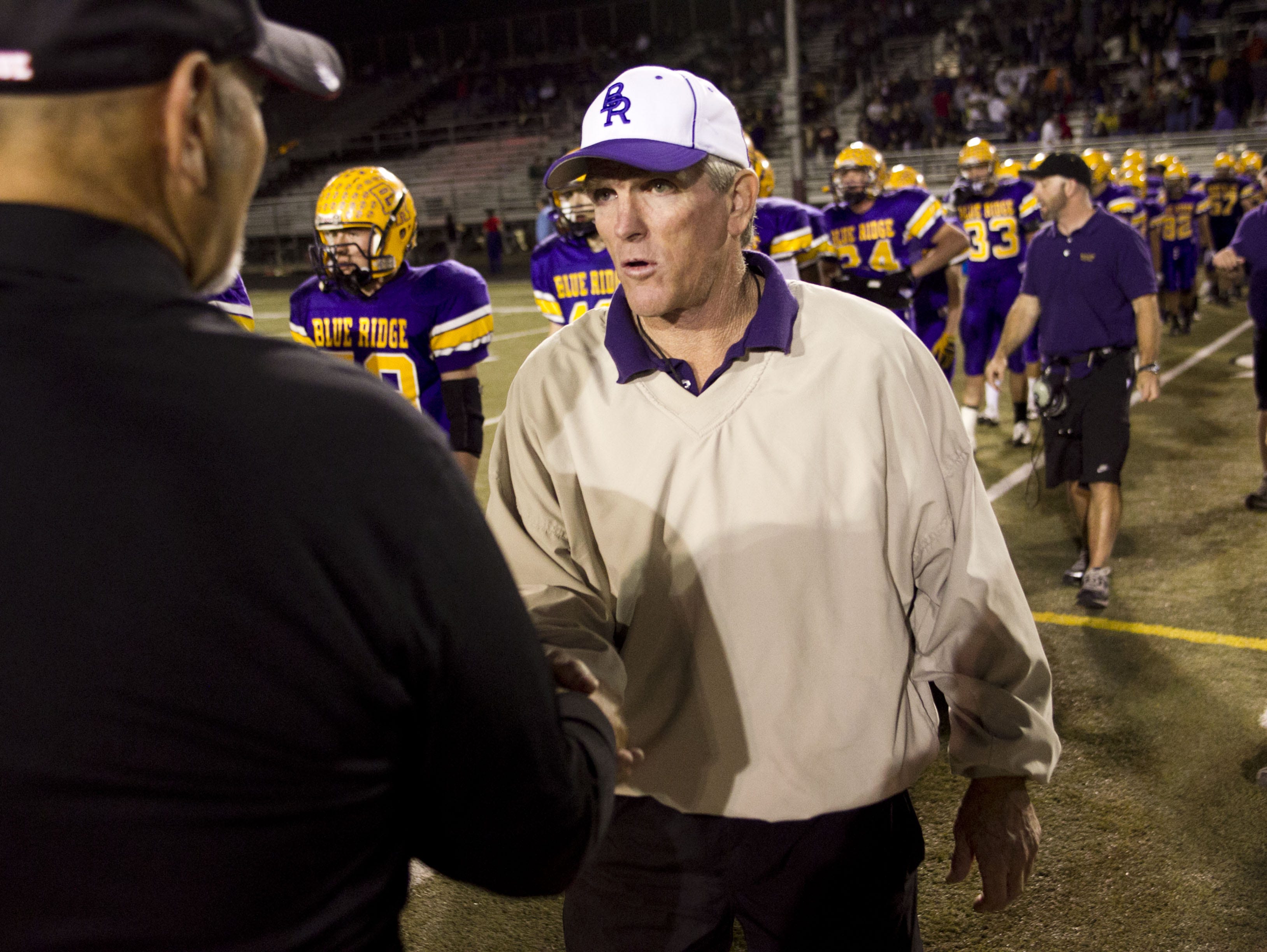 Lakeside Blue Ridge High head coach Paul Moro (center) shakes the hand of Florence High head coach George De la Torre after the Class 3A state high school football semifinals at Paradise Valley High School in Phoenix on November 20, 2010.