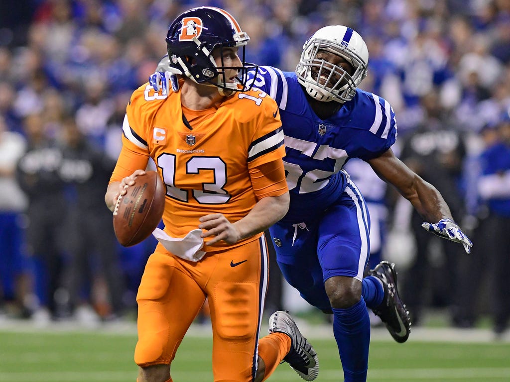 Denver Broncos quarterback Trevor Siemian runs out of the pocket while being pursued by Indianapolis Colts linebacker Barkevious Mingo in the first quarter at Lucas Oil Stadium in Indianapolis.