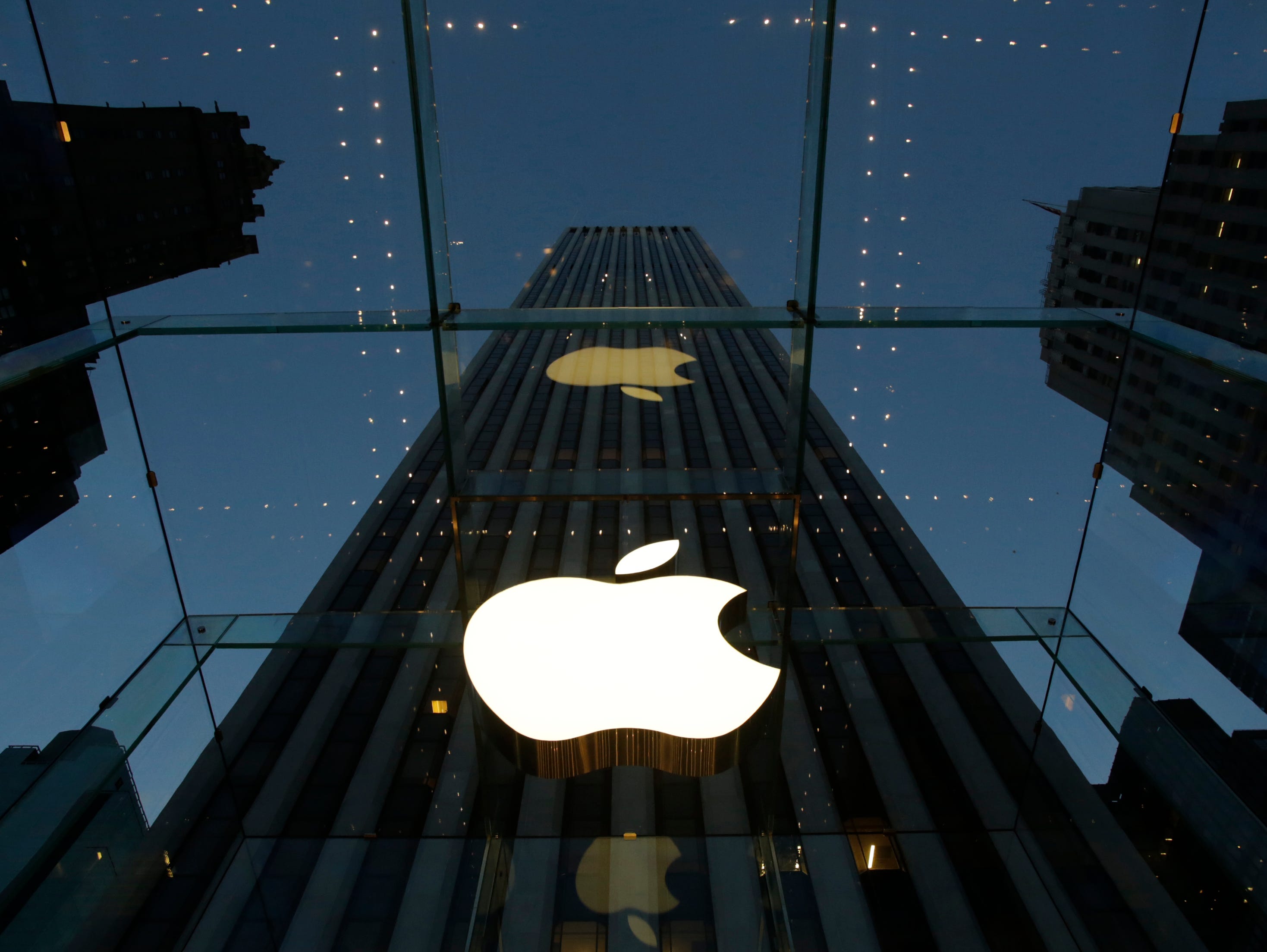 FILE - In this Wednesday, Nov. 20, 2013, file photo, the Apple logo is illuminated in the entrance to the Fifth Avenue Apple store, in New York. Six weeks ago, the iPhone and iPad maker announced plans to split its stock for the first time in nine ye