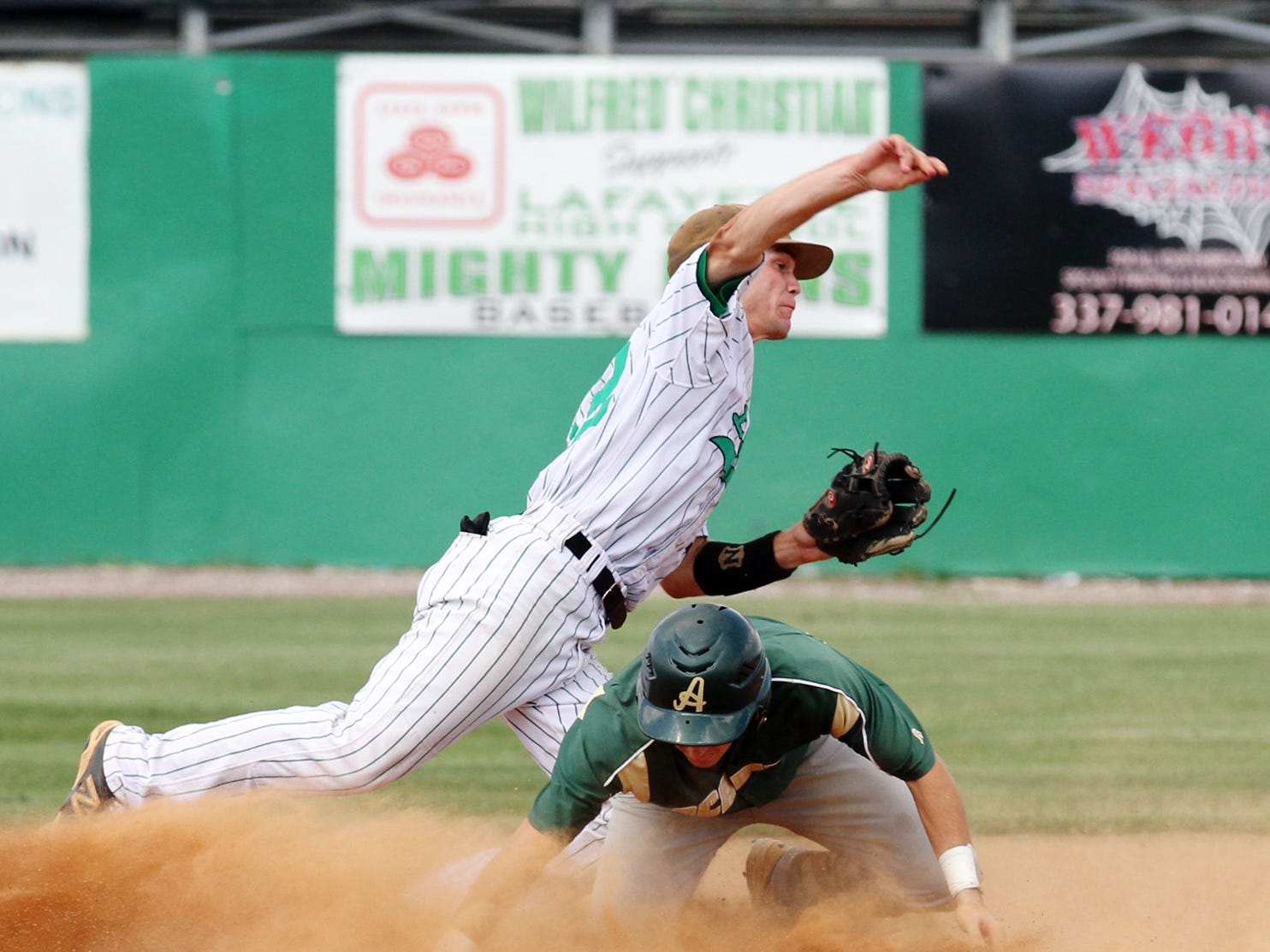 Lafayette High second baseman Owen Thibodeaux (12) attempts to complete a double play after forcing out Acadiana runner Brandon Duhon (8) at second base during Friday’s state regional round game one.