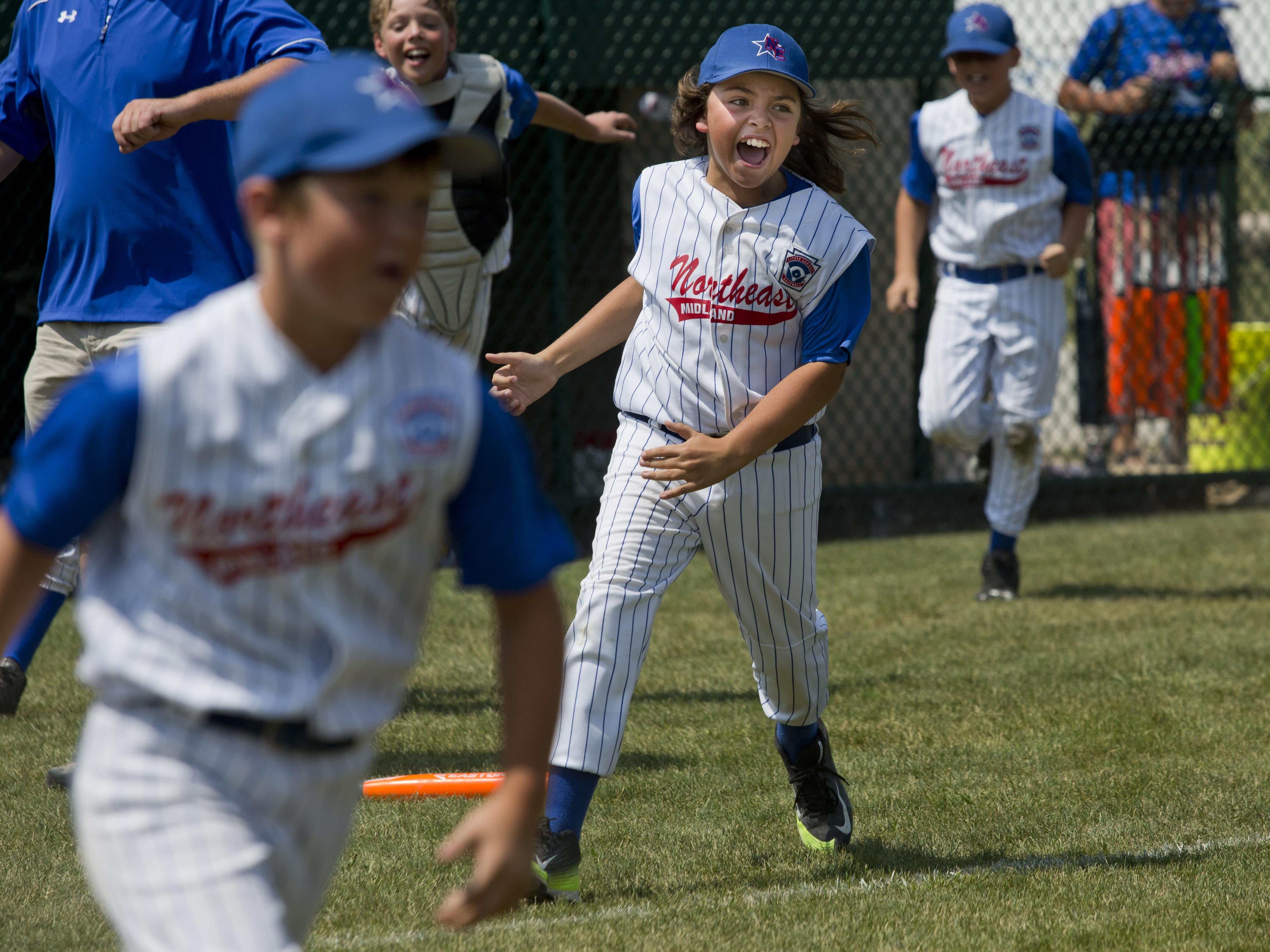 Midland Northeast's Fred Temple runs on to the field with his teammates after beating Bay City Northwest in a state final 10-and-under baseball game Wednesday, July 29, 2015 in St. Clair.