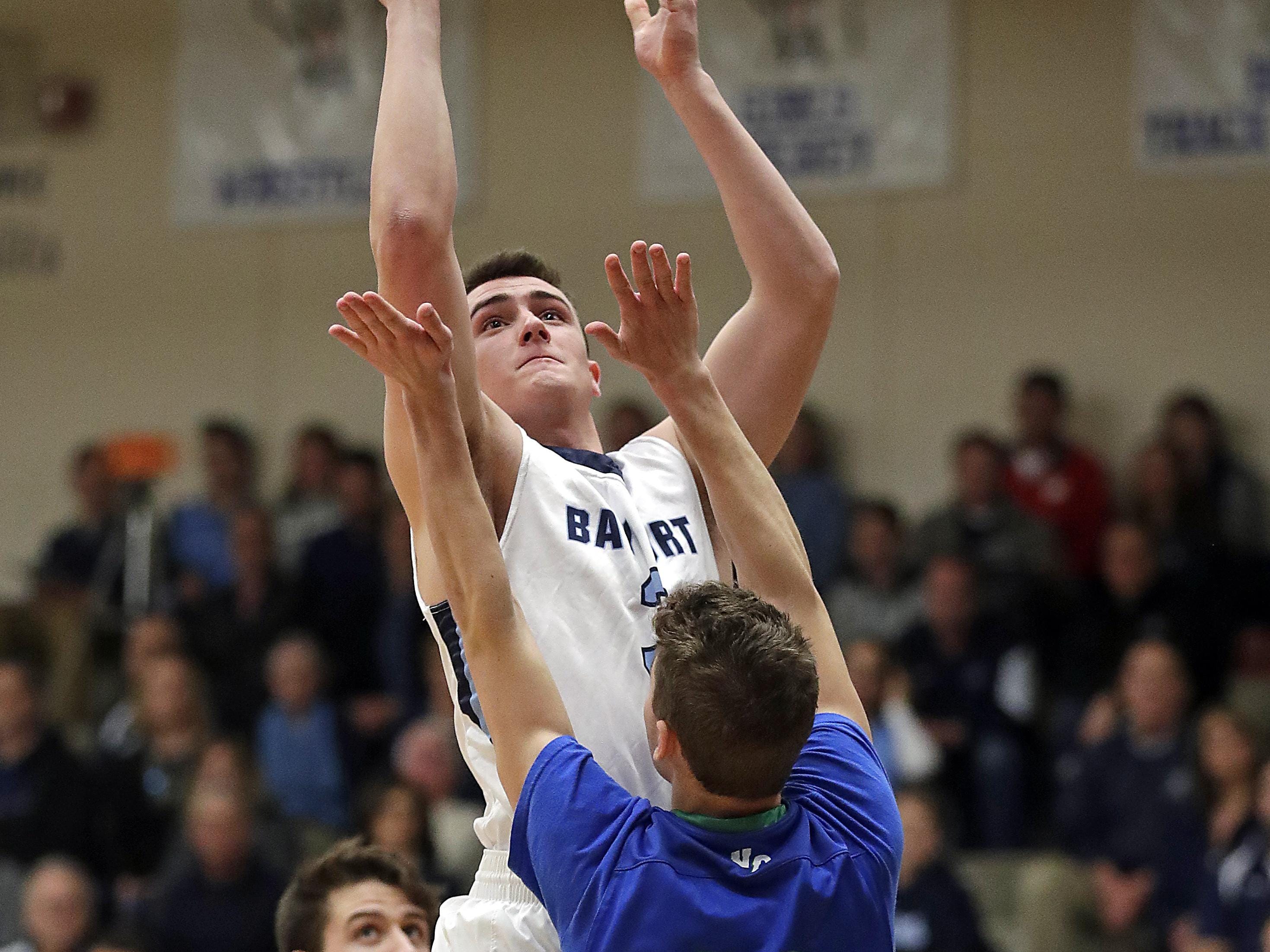 Bay Port guard Jacob Stratman goes up for a basket over Notre Dame’s Reese Johnson during FRCC action at Bay Port High School on Thursday.