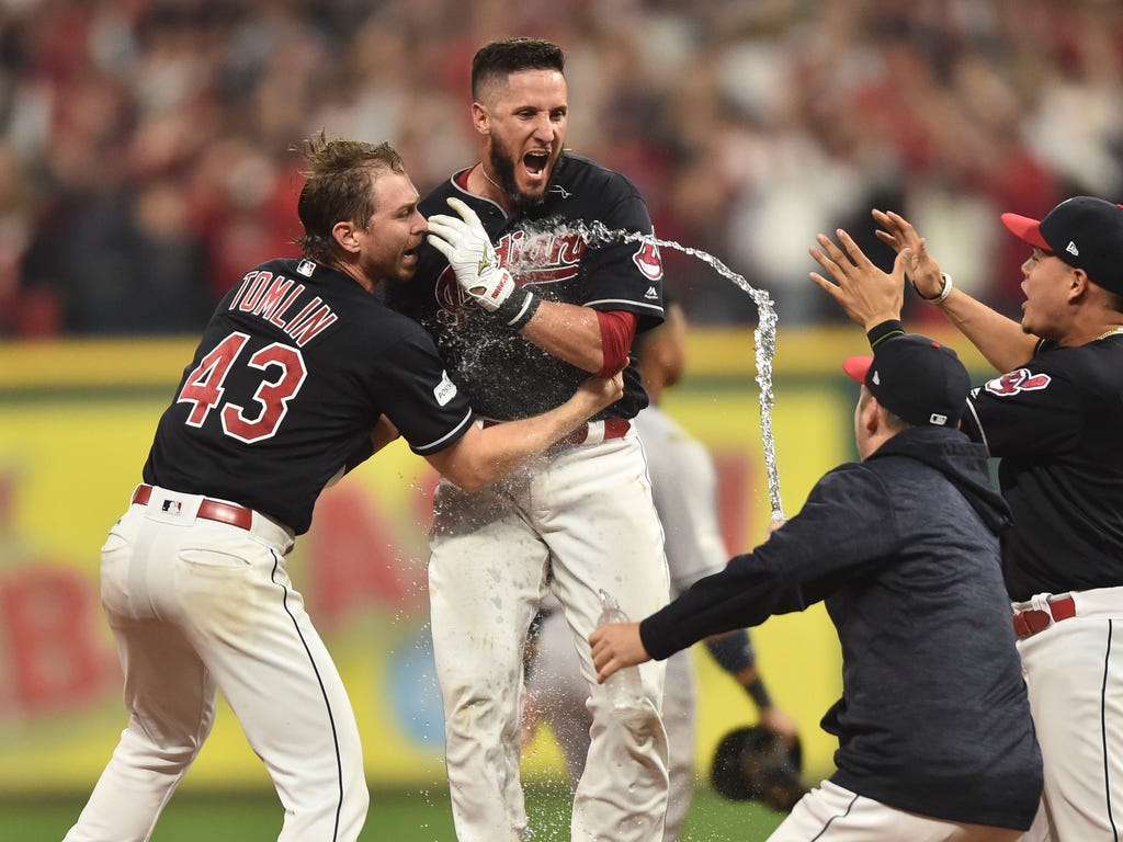 Indians hitter Yan Gomes, center, celebrates his game-winning RBI beat the Yankees in Game 2 of the ALDS in Cleveland. Gomes' 13th-inning hit gave the Indians a 9-8 win and a 2-0 series lead.