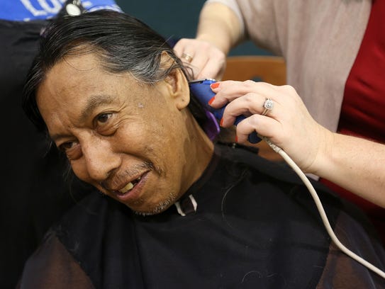 Milo Soto, 56, of Salem, has his hair trimmed by volunteer