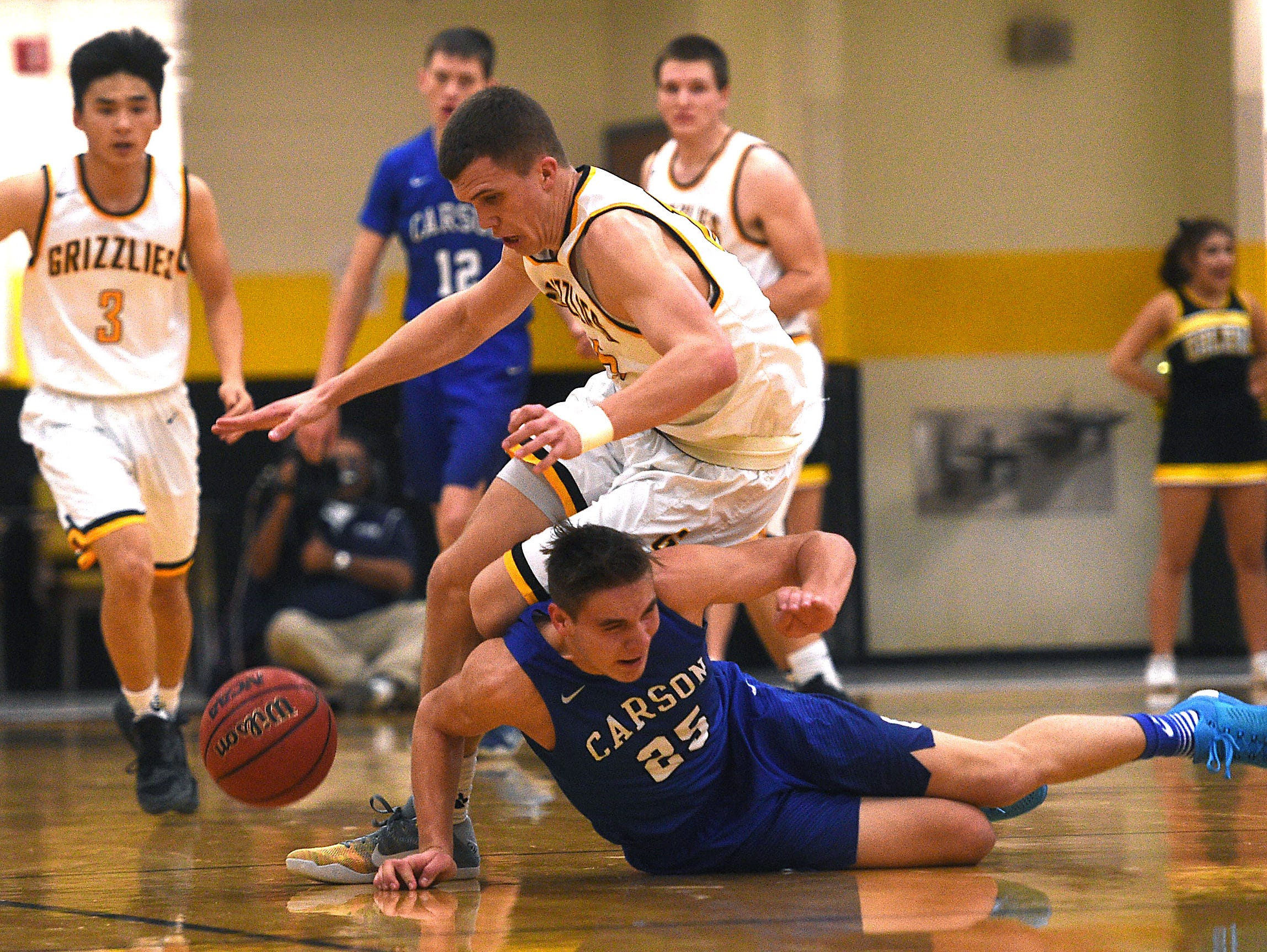 Galena's Dillon Voyles (15) battles Carson's Jayden Dejoseph (25) for a loose ball during their basketball game at Galena on Friday