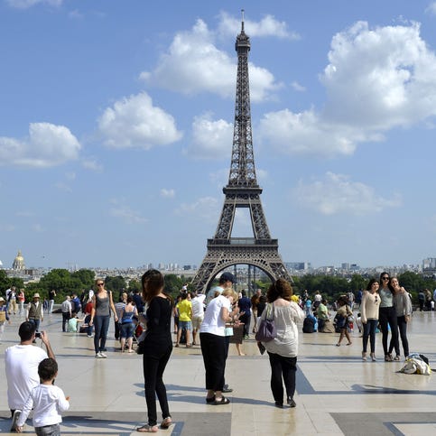 People stand and take photographs at the Human rights square in front of the Eiffel Tower in June 2014.