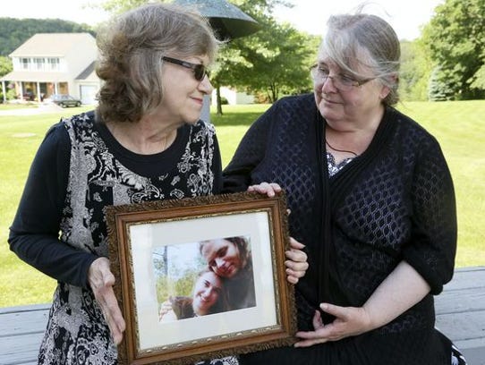 Lyn Coleman and Linda Boyle hold a picture of their