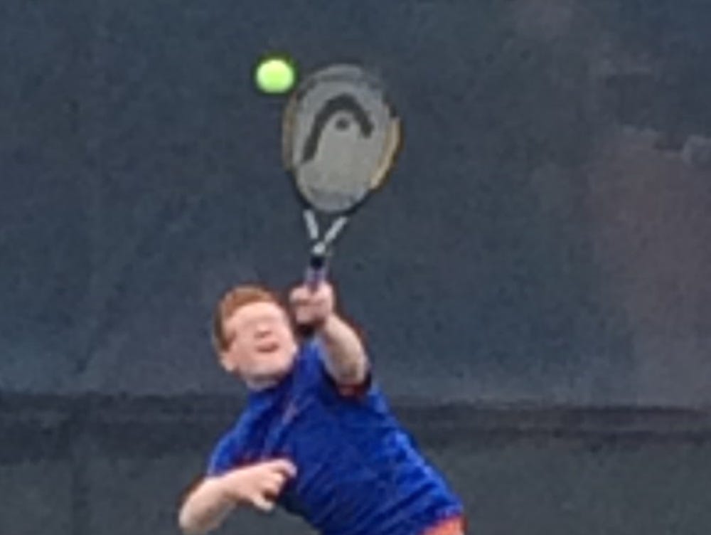 Garden City's Jassen Matusczak puts everything he has into a serve.