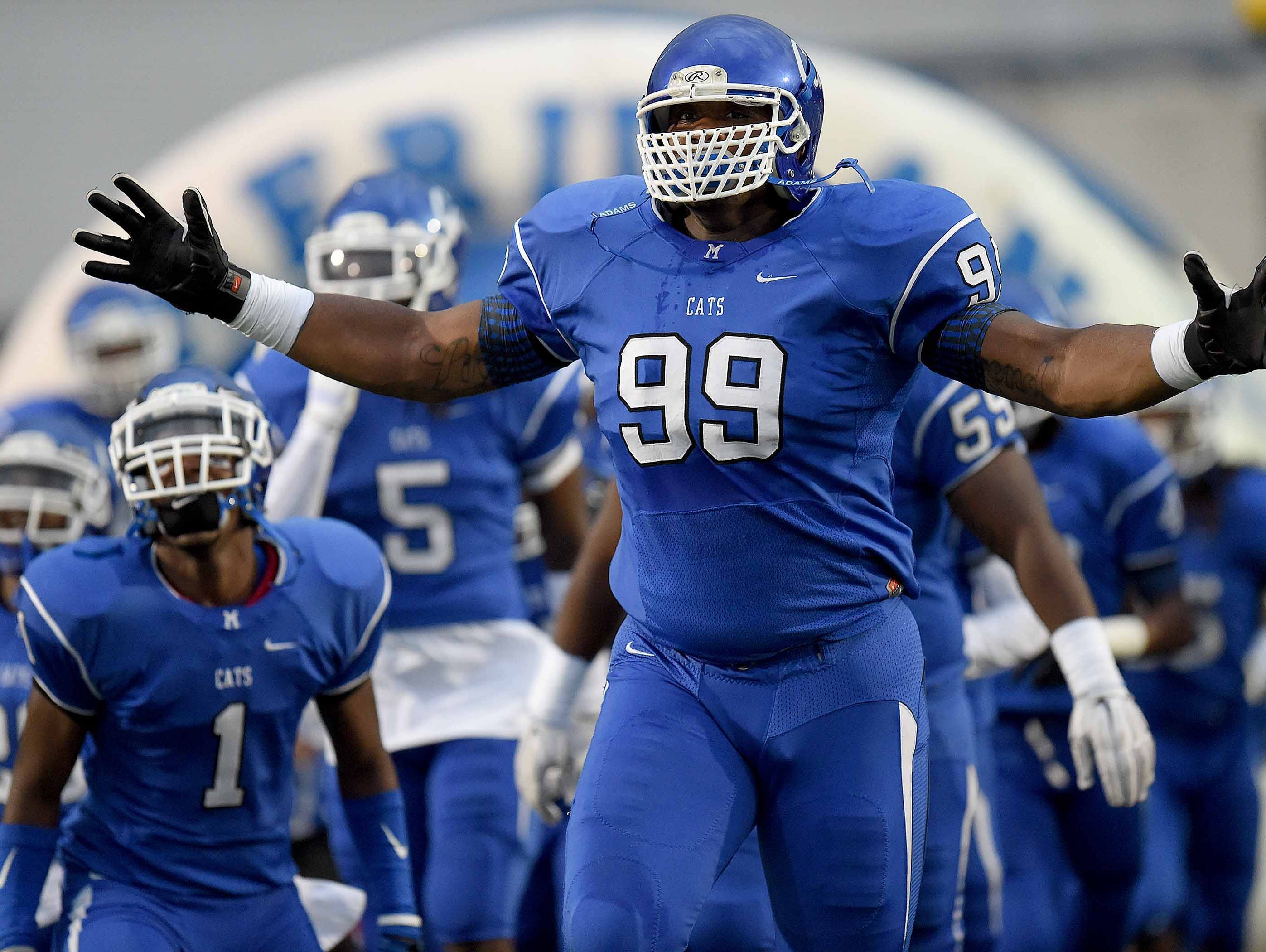 Meridian defensive tackle Raekwon Davis leads the Wildcats onto the field
