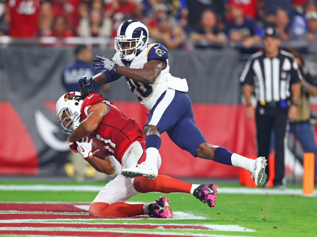 Arizona Cardinals wide receiver Larry Fitzgerald, left, catches a touchdown pass against Los Angeles Rams safety Lamarcus Joyner in the second quarter at University of Phoenix Stadium.