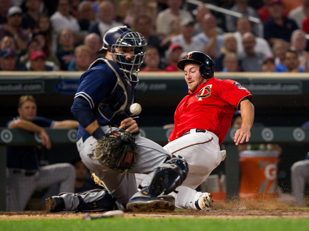 Minnesota Twins designated hitter Robbie Grossman slides safely into home plate in the second inning against San Diego Padres catcher Austin Hedges at Target Field in Minneapolis.