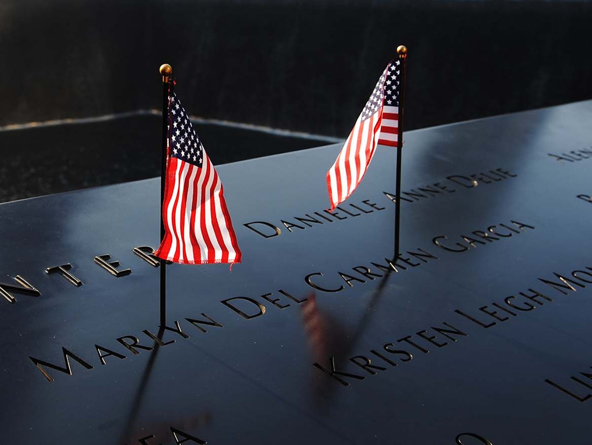 American flags decorate a name on the 9/11 Memorial during a ceremony commemorating the 12th anniversary of the 9/11 terrorist attacks at the World Trade Center site on Sept. 11 in New York City. Ceremonies are being held to honor victims of the 2001 terror attacks, when hijacked airliners slammed into the World Trade Center in New York, the Pentagon in Arlington, Va., and a field in Shanksville, Pa.
