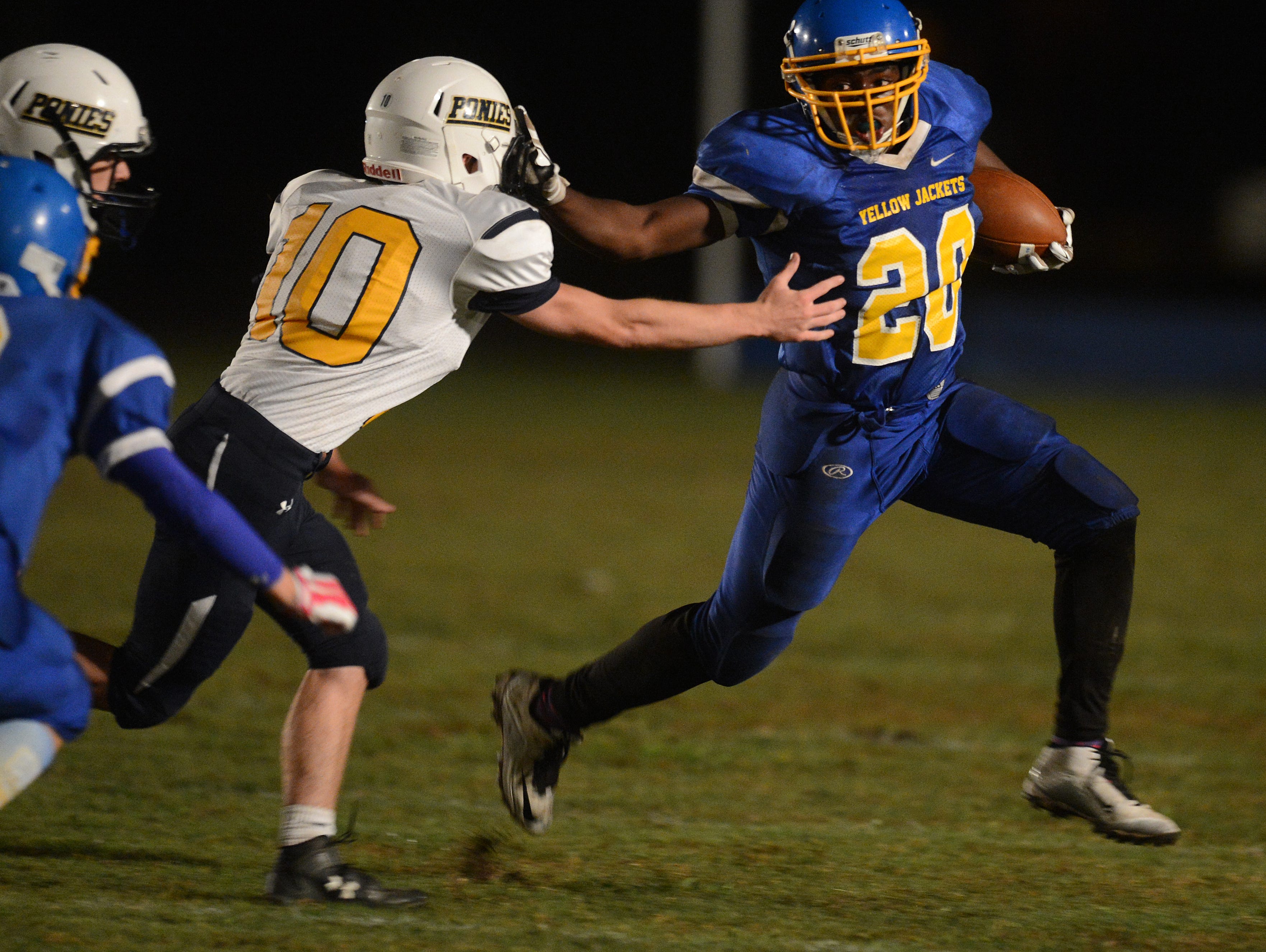 Northampton's Dyshawn Beckett (20) stiff arms Chincoteague's Dustin Holloway (10) as he carries the ball on Friday, Oct. 16, 2015. Chincoteague would win the game 34-28.
