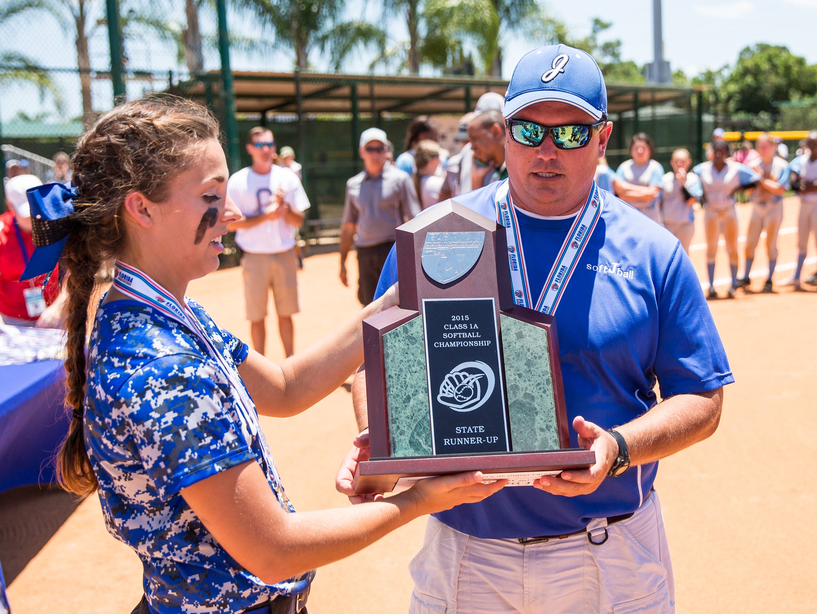 Jay High School Royals Miranda Roberts and Coach Brian Watson accept the Class 1A State Runner-up trophy after the game against Chiefland in the Class 1A state softball final at Historic Dodgertown in Vero Beach, FL on Thursday.