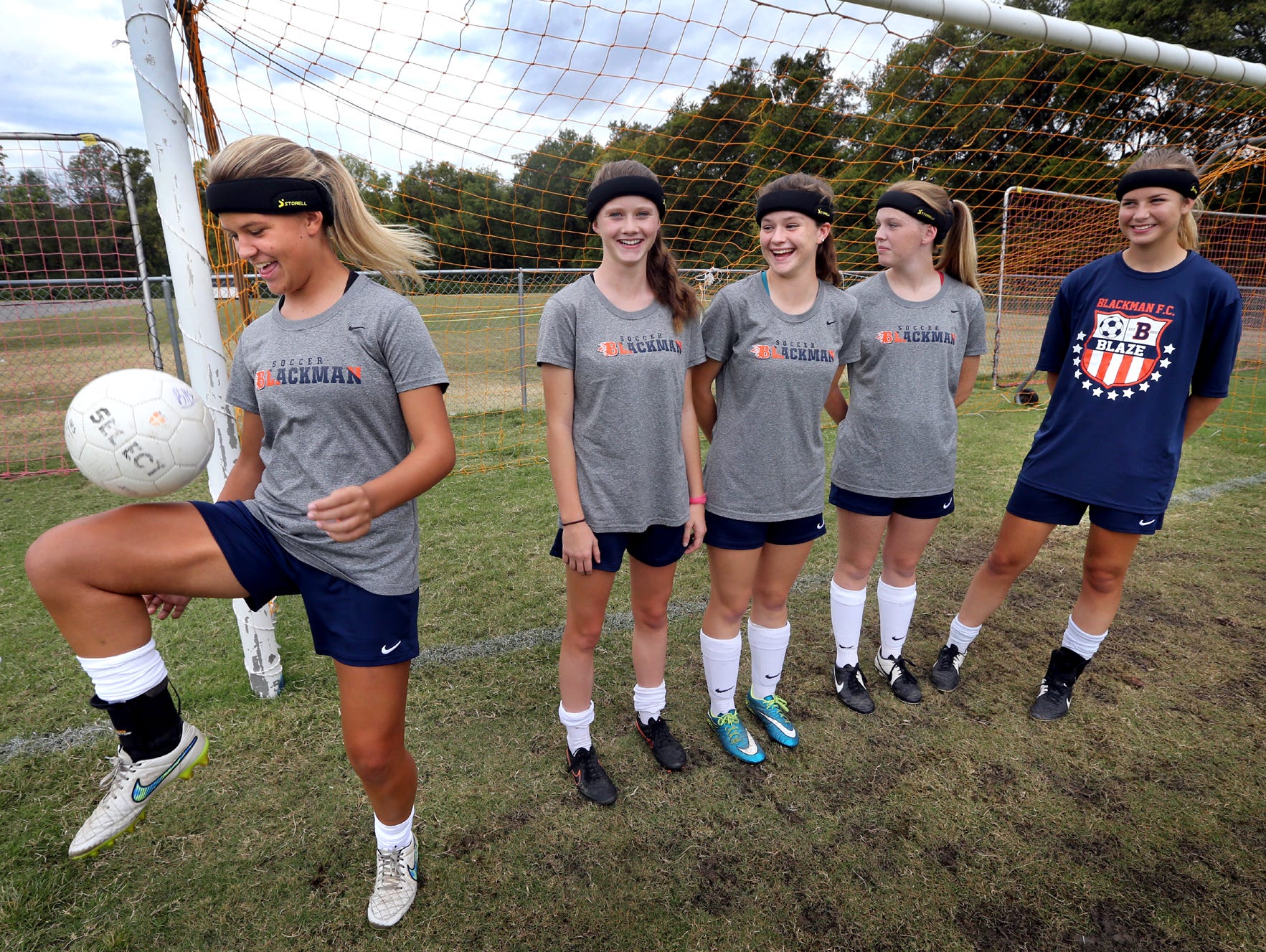 Blackman's Kenzi Vetter, a sophomore, left juggles the soccer ball while wearing a headband that all Blackman girls soccer players must wear before getting on the field for either a game or practice, on Monday, Sept. 28, 2015, before a game against Smyrna. The headbands are suppose to lessen the chances of receiving a concussion. Vetter's teammates (L to R) Katelyn Davis, a freshman, Emily Nash, a junior, Mallory Conlin, a sophomore, and Amelia Goodnight, a junior stand behind Vetter as she juggles the ball and are all wearing the same headband.