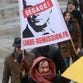 A woman holds a banner dispaying a portrait of the French President Francois Hollande with the phrase "Get out!" during a demonstration called by the Collective "Day of Wrath", supported among others by the conservative Printemps Francais ("French Spring") movement and the fundamentalist christian group Civitas, to protest against the French President's policy, on Jan. 26, 2014 in Paris.