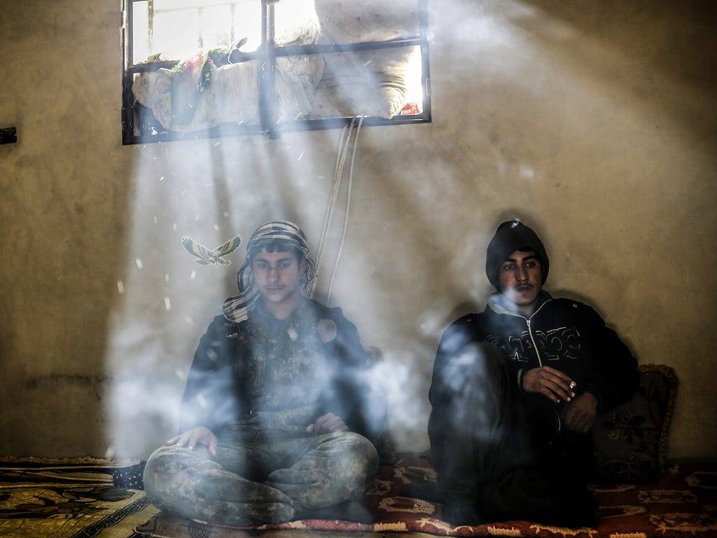 Kurdish fighters rest in a house on March 30 outside Kobane, Syria.