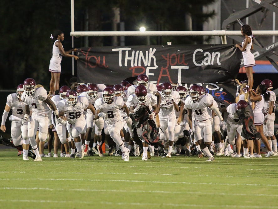 The Tigers run onto the field Friday night at Pine Forest High School.