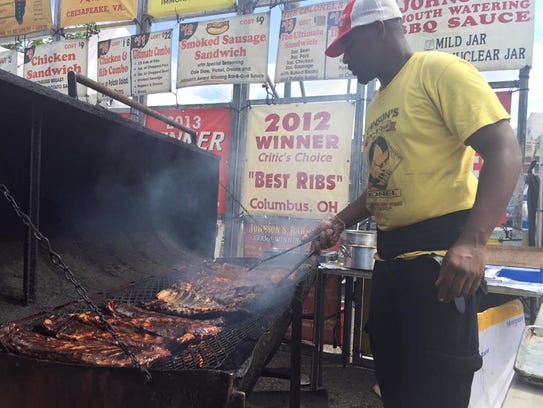 An employee from Johnson's Bar-BQue turns ribs on a