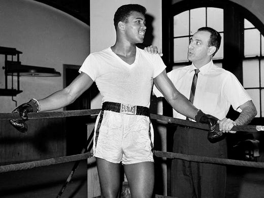 In this Feb. 8, 1962, file photo, young heavyweight fighter Cassius Clay, who later changed his name to Muhammad Ali, is seen with his trainer, Angelo Dundee, at City Parks Gym in New York.