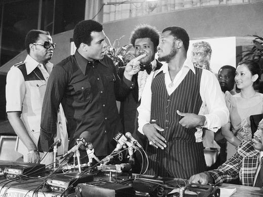 World heavyweight champion Muhammad Ali, left, points at challenger Joe Frazier at a news conference in New York City, Thursday, July 17, 1975, to promote the "Thrilla in Manila."  Standing between the fighters is boxing promoter Don King.