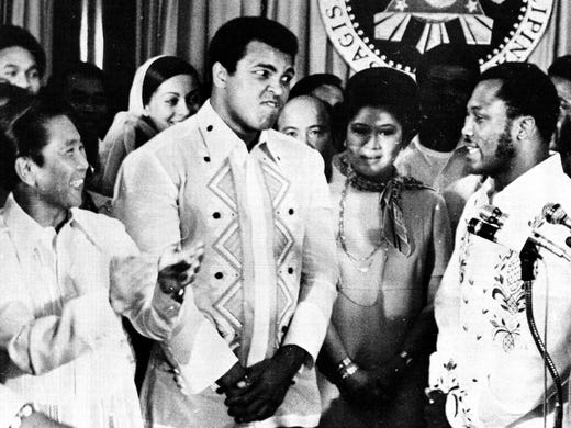 Philippines President Ferdinand Marcos, left, applauds as challenger Joe Frazier, right, makes some remarks about world champion Muhammad Ali, second from left, during their call on Marcos at the Malacanang Palace in Manila, Sept. 18, 1975.