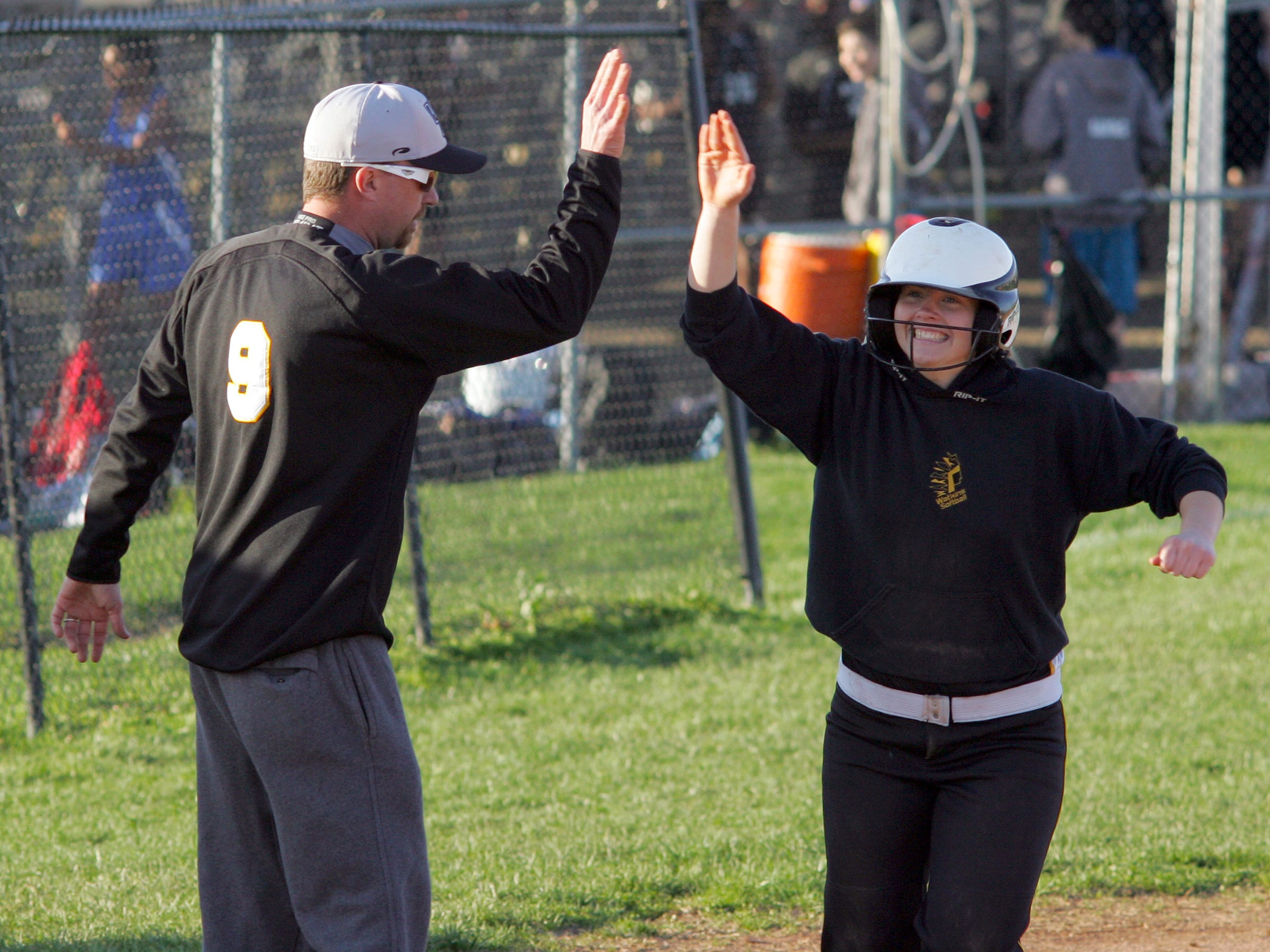 Watkins Memorial’s Anna Shroyer high fives coach Mike Jellison after hitting a home run this past Friday during the team’s 14-11 victory against Licking Heights.