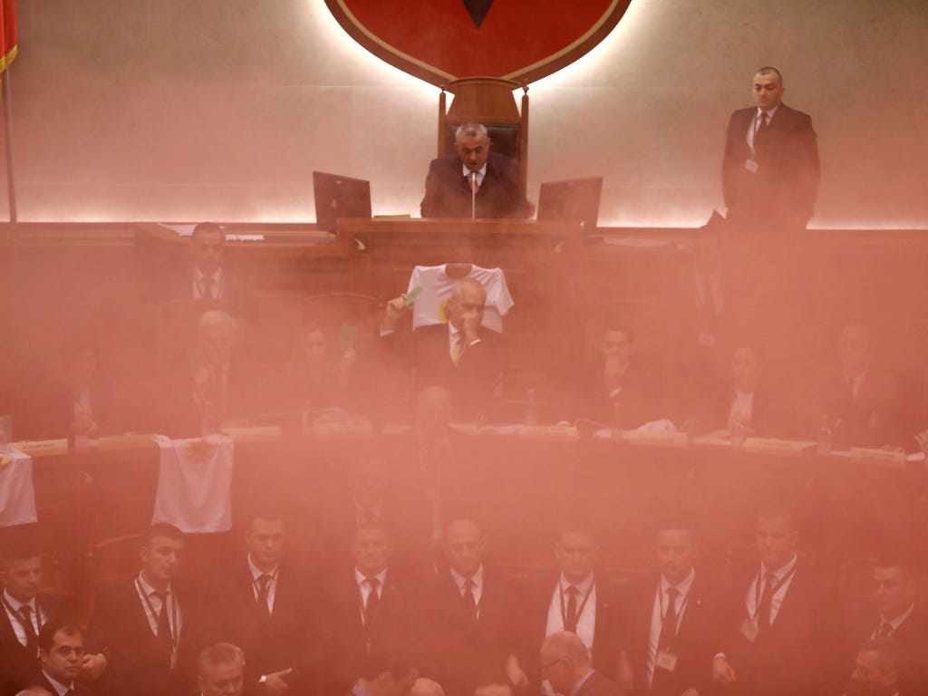 Members of Albania's parliament react as opposition MPs set off smoke bombs during a vote for a new, temporary general prosecutor on Dec. 18, 2017 in Tirana. \u000dRight-wing opposition MPs smuggled smoke grenades into the Albanian parliament hall on