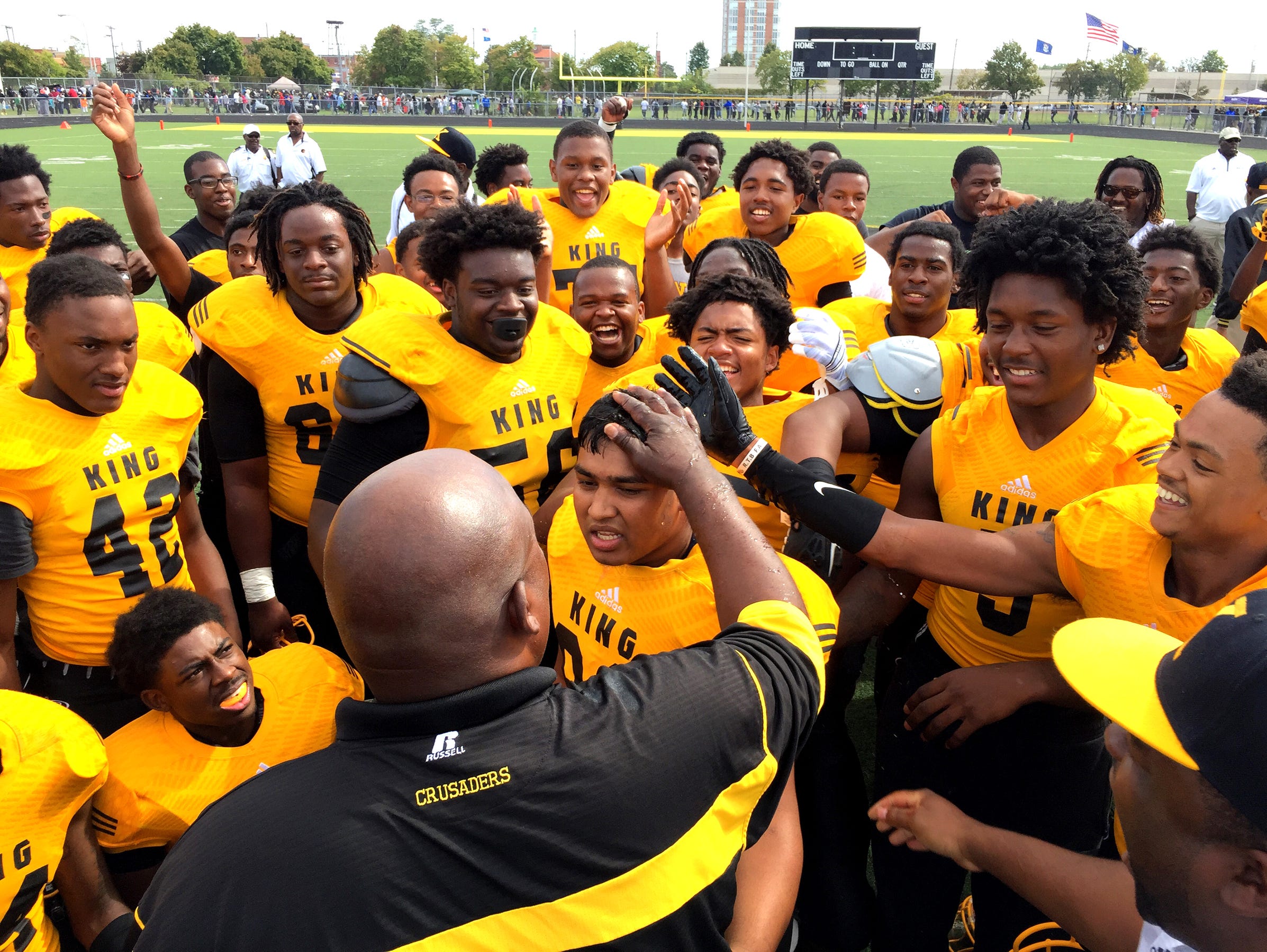 Detroit King football coach Dale Harvel, foreground, congratulates his team after beating Detroit Cass Tech on Sept. 26, 2015.