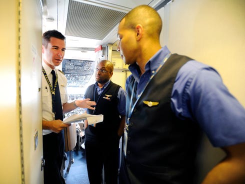 , left, discusses the flight plan in May 2013 with flight attendants ...