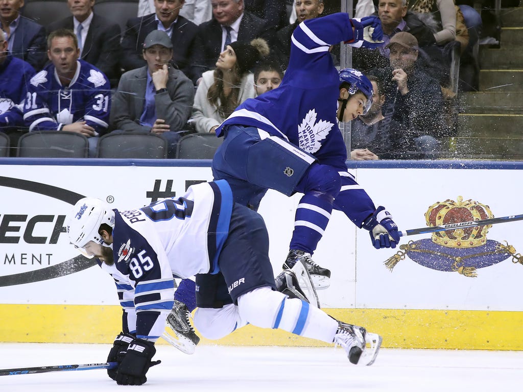 Toronto Maple Leafs defenseman Connor Carrick, right, is hit by Winnipeg Jets center Mathieu Perreault at Air Canada Centre in Toronto.