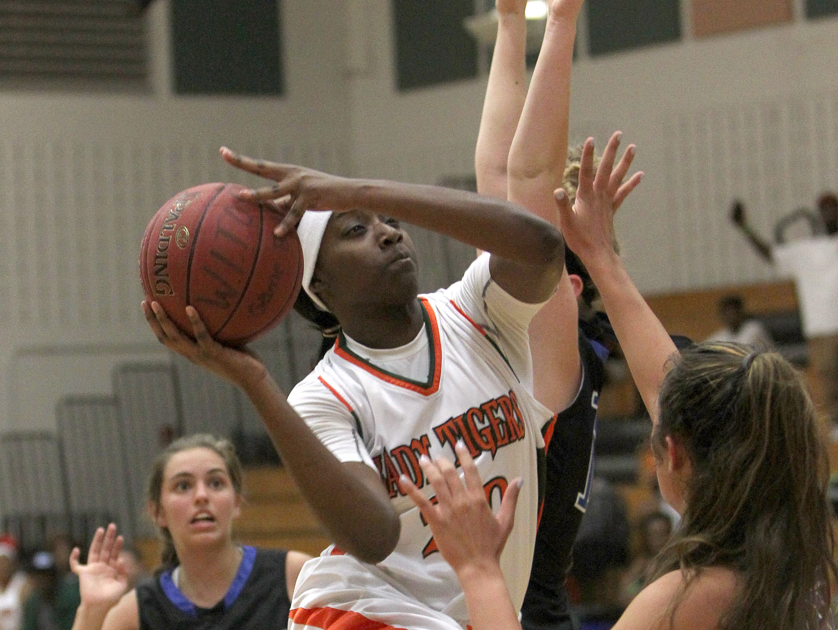 Dunbar's Respect Leaphart, center, barrels her way through a trio of The Master's Academy guards at the Queen of Palms tournament in Fort Myers Tuesday.