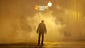 A man walks through a cloud of tear gas as police enforce