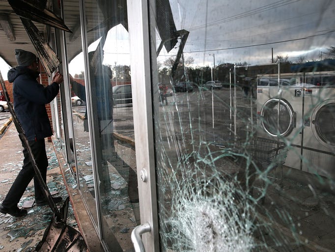 A reporter looks through the window of a laundromat