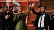 Adele reacts on stage after she breaks the Grammy trophy