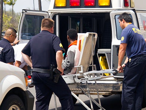 A 16-year-old boy who stowed away in the wheel well of a flight from San Jose, Calif., to Maui, on stretcher at center, is loaded into an ambulance at Kahului Airport in Kahului, Maui, Hawaii Sunday afternoon, April 20, 2014. Officials say the boy is