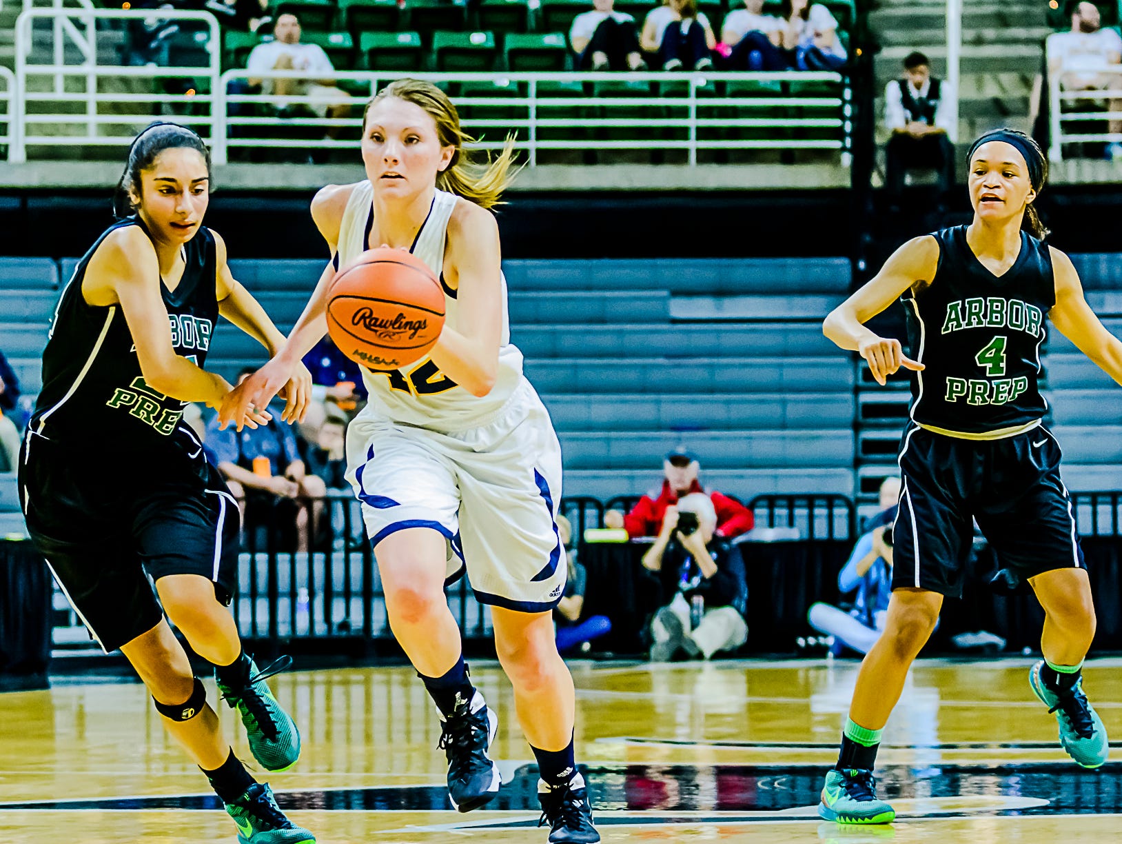 Kayla Belles ,center, of Ithaca dribbles out of a double-team by Kayla Knight ,left and Nastassja Chambers ,right, of Ypsilanti Arbor Prep Thursday at the Breslin Center in East Lansing.