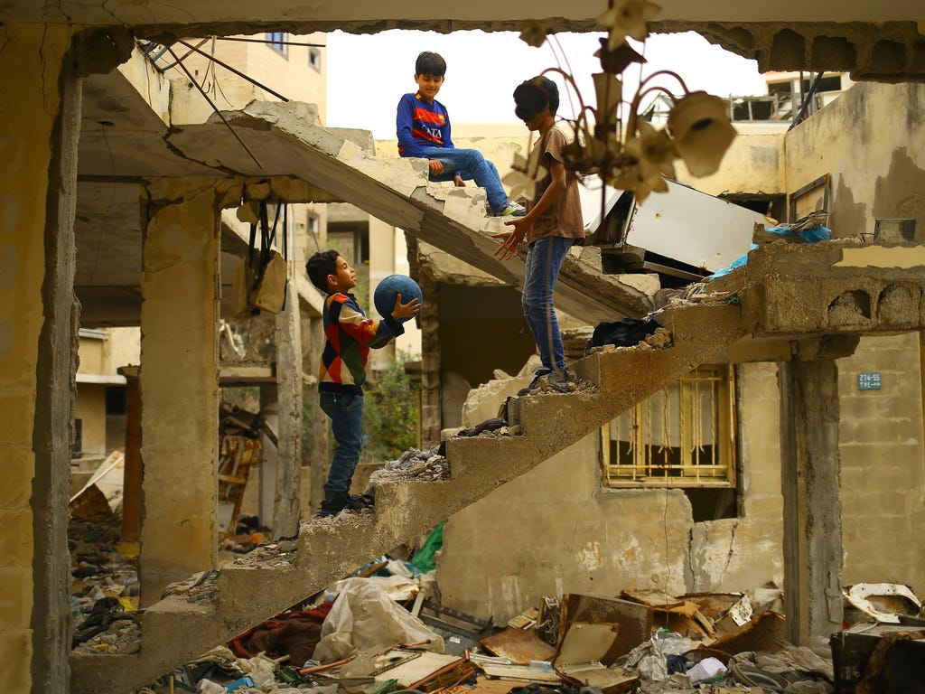 Palestinian children play amidst the ruins of a building destroyed during the 50-day war between Israel and Hamas militants during the summer of 2014 in Gaza City, on April 13, 2017.