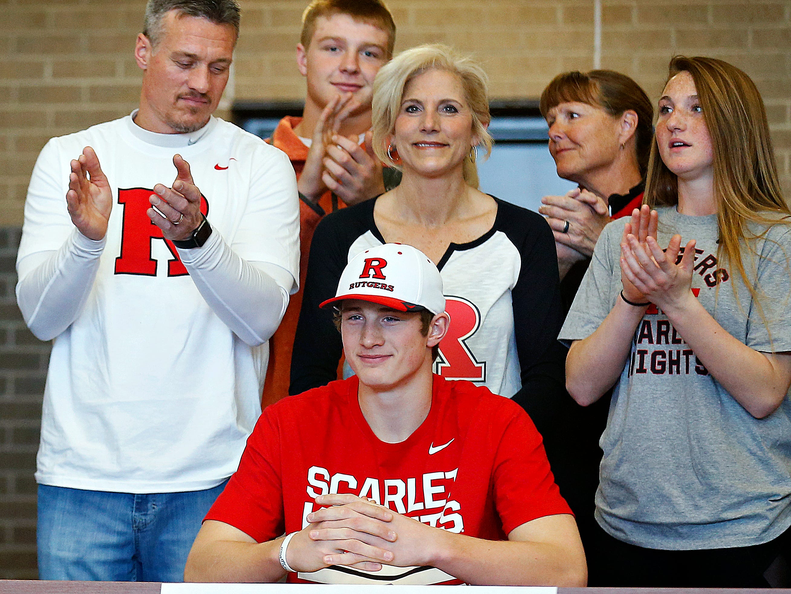 Travis Vokolek and his family smile while taking part in a National Signing Day ceremony held at Kickapoo High School in Springfield, Mo. on Feb. 1, 2017.
