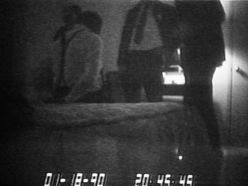 Image an FBI videotape shows FBI agents standing over a handcuffed District of Columbia Mayor Marion Barry, sitting on a bed on Jan. 18, 1990.