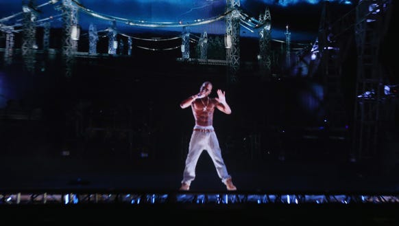 A hologram of Tupac Shakur performs onstage during