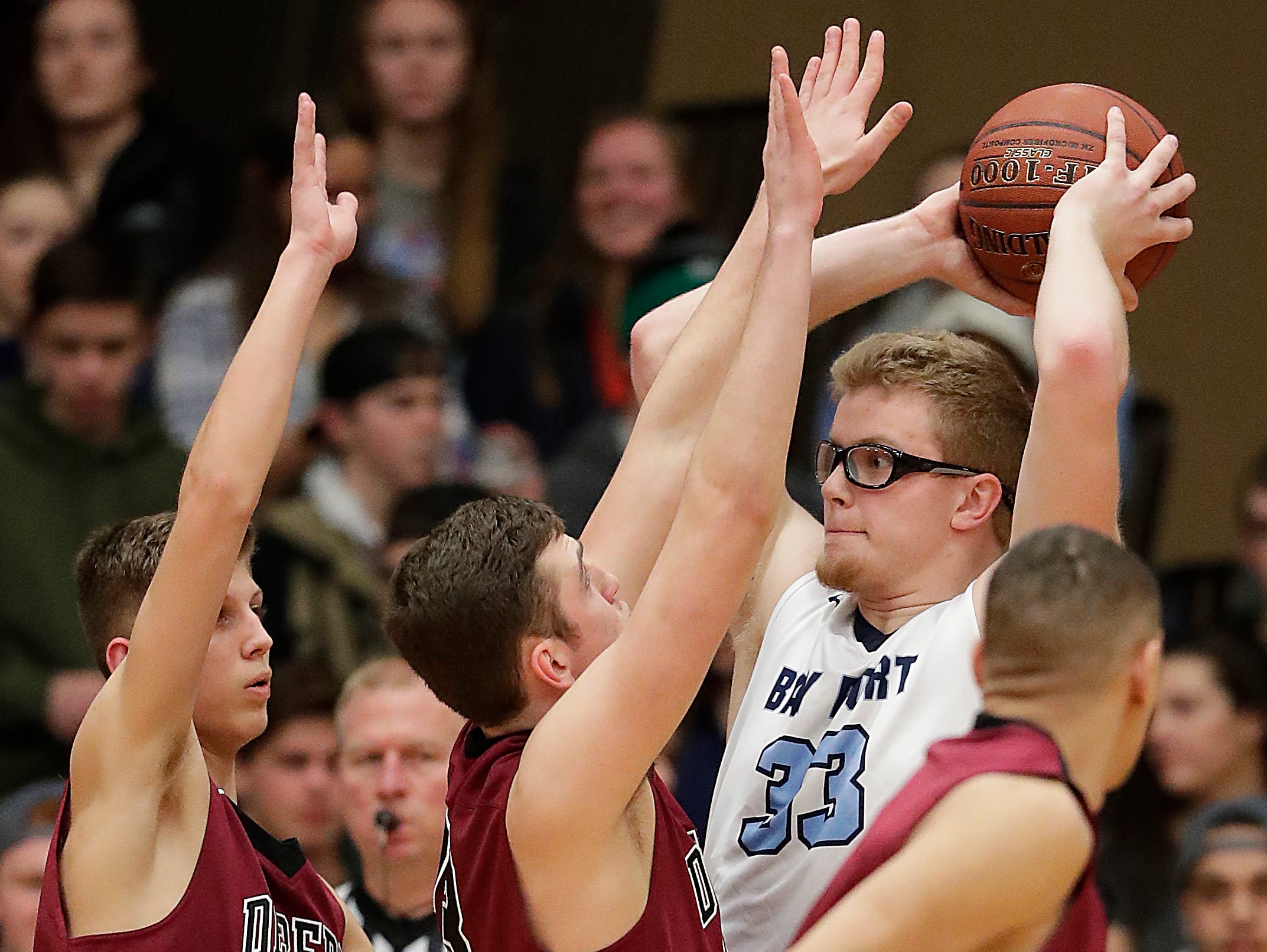 Bay Port center Jack Plumb is surrounded down low in a Fox River Classic Conference boys basketball game against De Pere on Friday. It was the Pirates' 10th straight win.