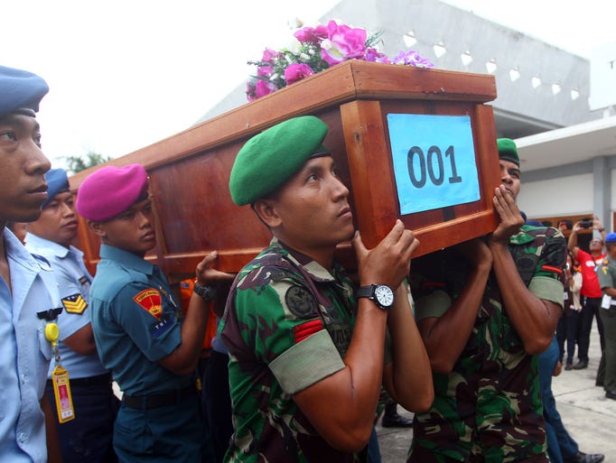 Indonesian soldiers carry the coffin of an AirAsia