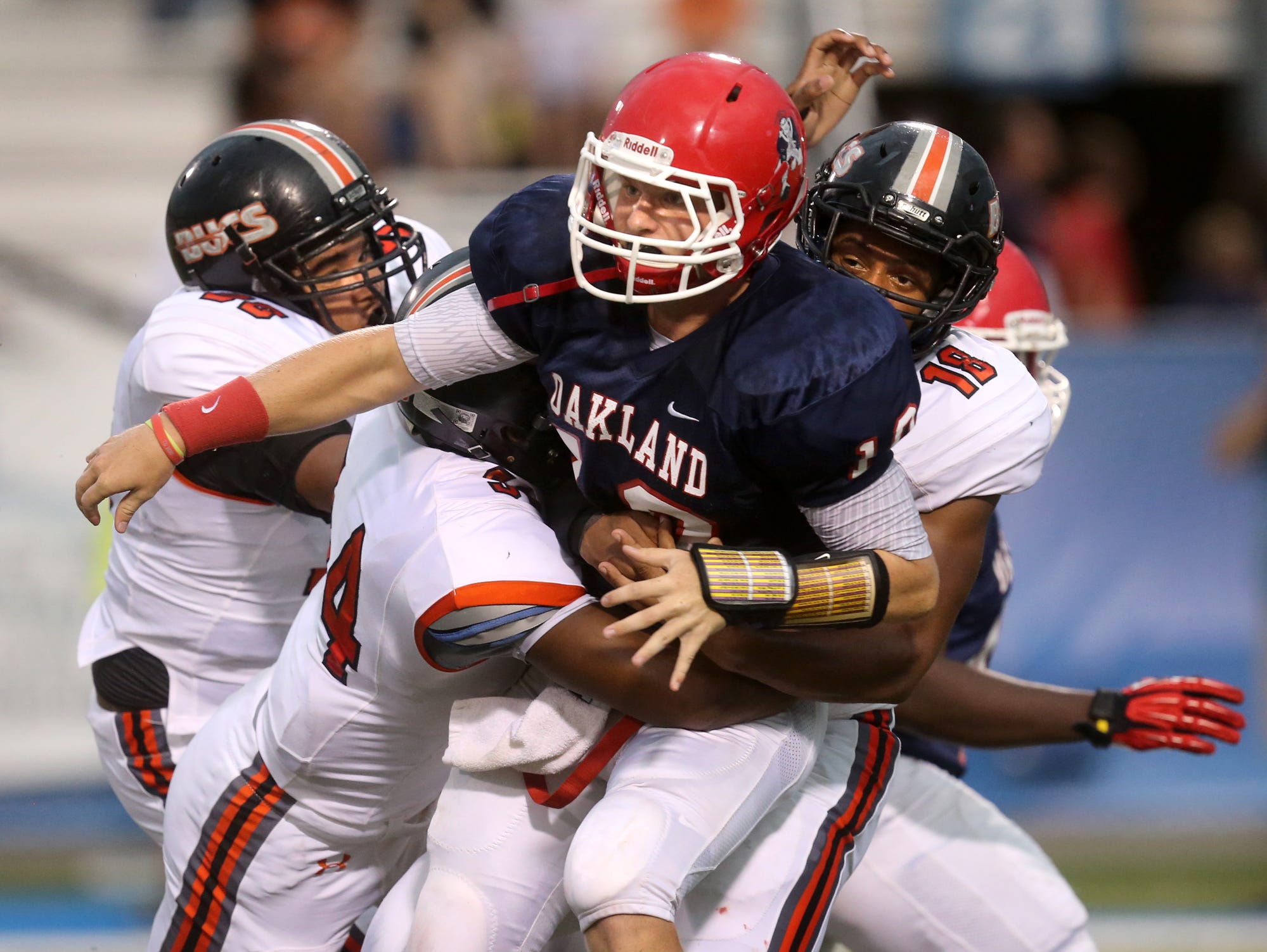 Oakland's quarterback Brendon Matthews (10), gets tackled by Hoover players at the Middle Tennessee Classic at MTSU's Floyd Stadium, on Saturday, Aug. 22, 2015.