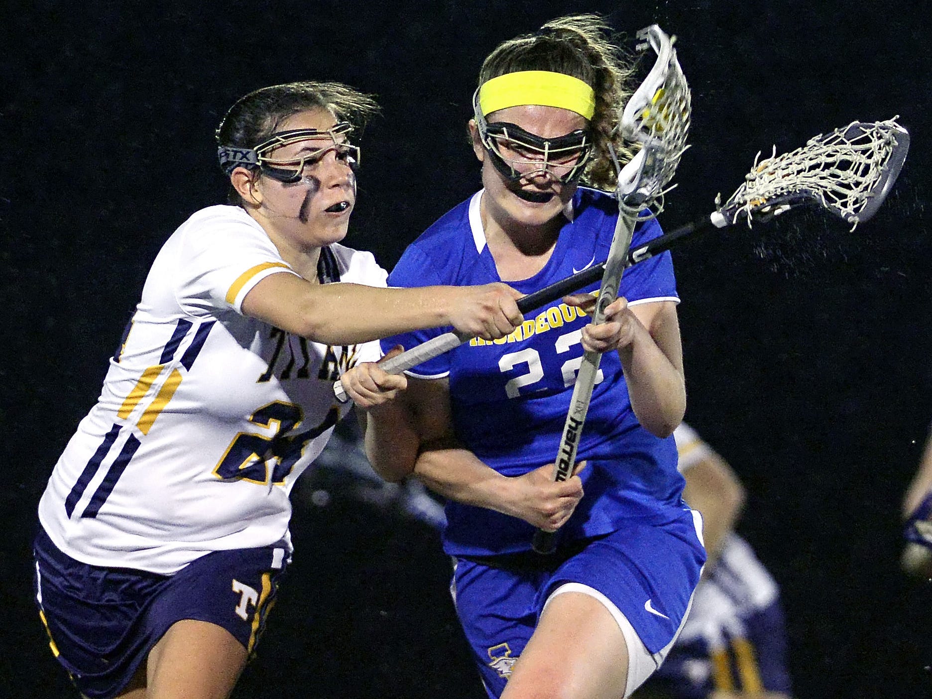 Webster Thomas' Emily Resnick, left, defends against Irondequoit's Katie Miller during a regular season game played at Webster Thomas High School on Monday, April 13, 2015.