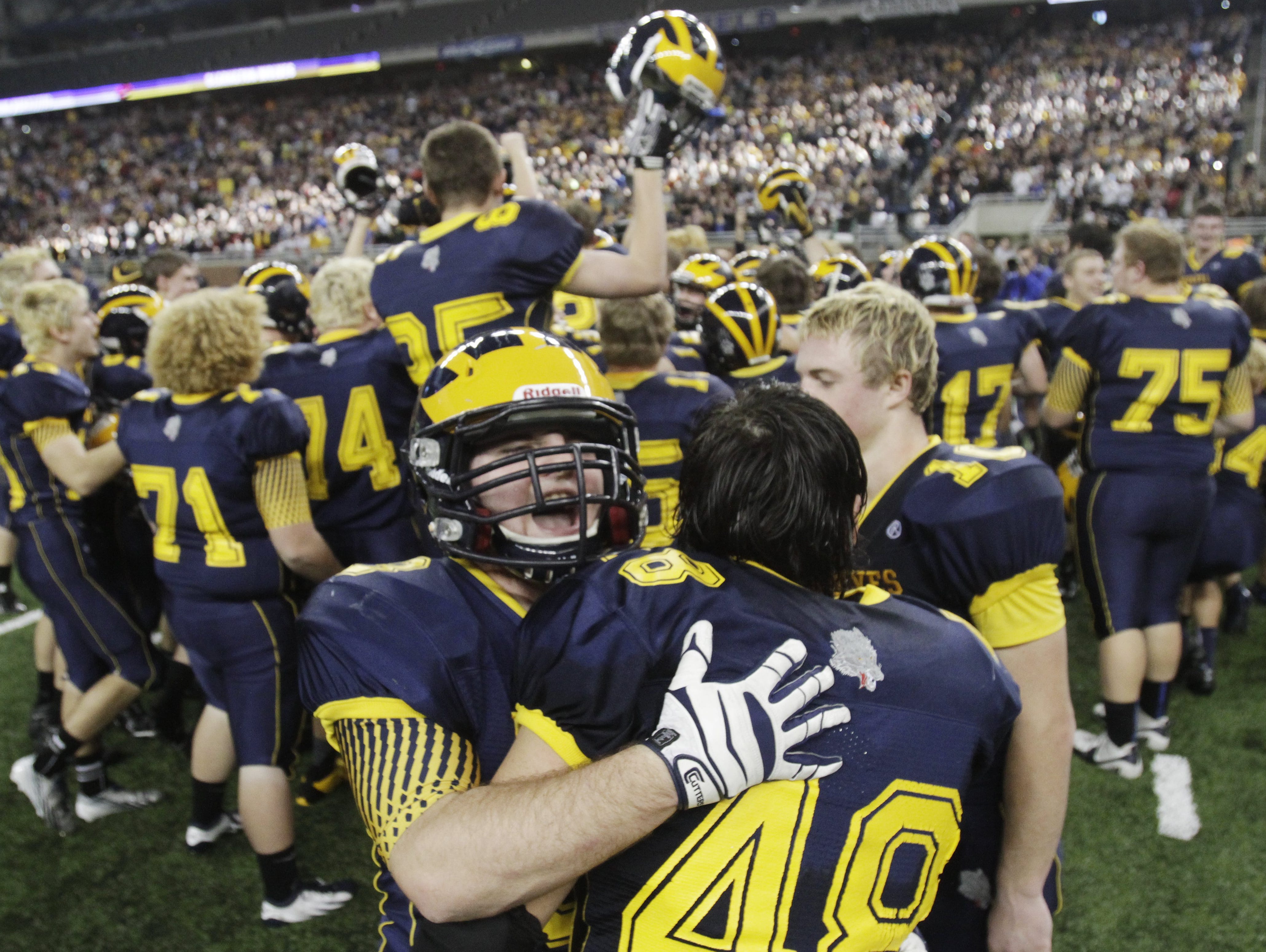 Clarkston players celebrate their Division 1 title win against Novi Detroit Catholic Central on Nov. 30, 2013, at Ford Field.