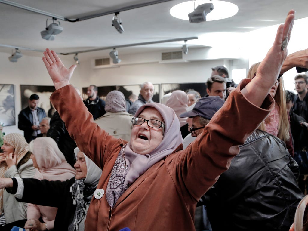 A Bosnian woman raises her arms upon hearing the sentence at the end of former Bosnian Serb military chief Gen. Ratko Mladic's trial at the memorial center in Potocari, near Srebrenica, Bosnia.  A U.N. court has convicted former Bosnian Serb military